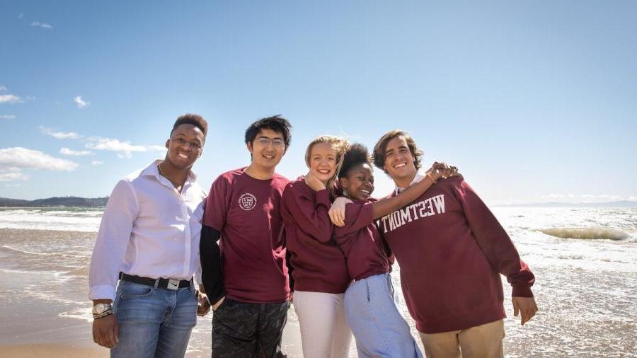 international westmont students hugging on beach